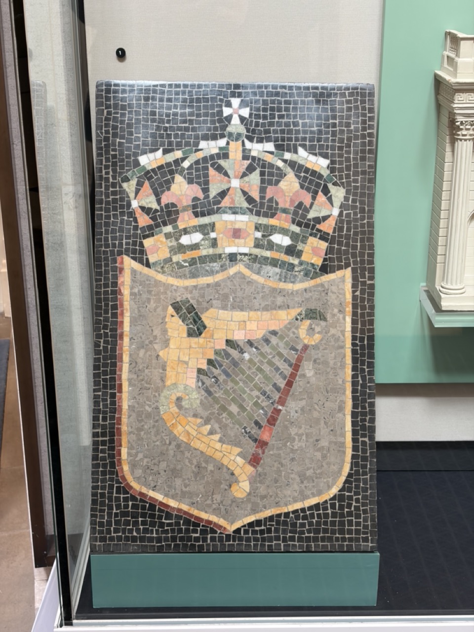 Photograph of a Irish harp beneath British crown on a mosaic crest, 1937. Displayed within the Bank of England Museum